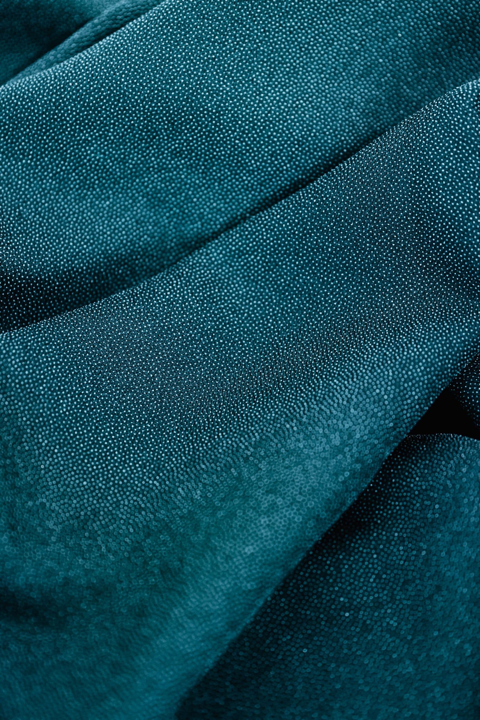 Close view of folded blue-green woven fabric