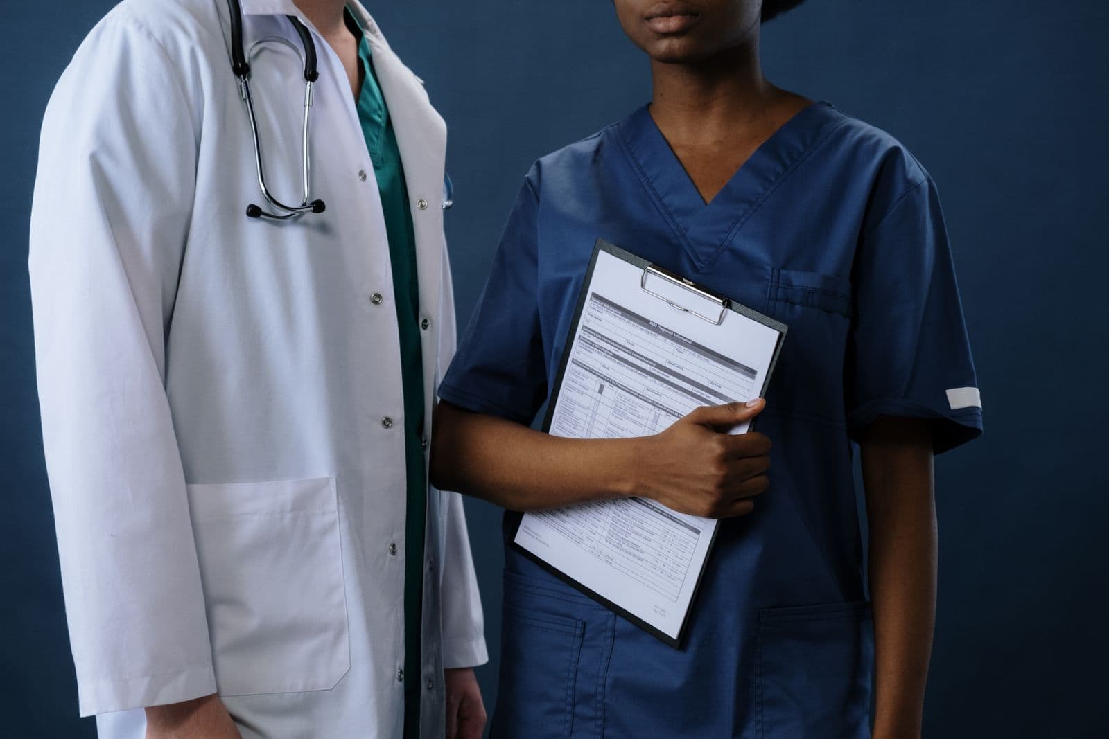 Healthcare uniforms shown against a navy studio background